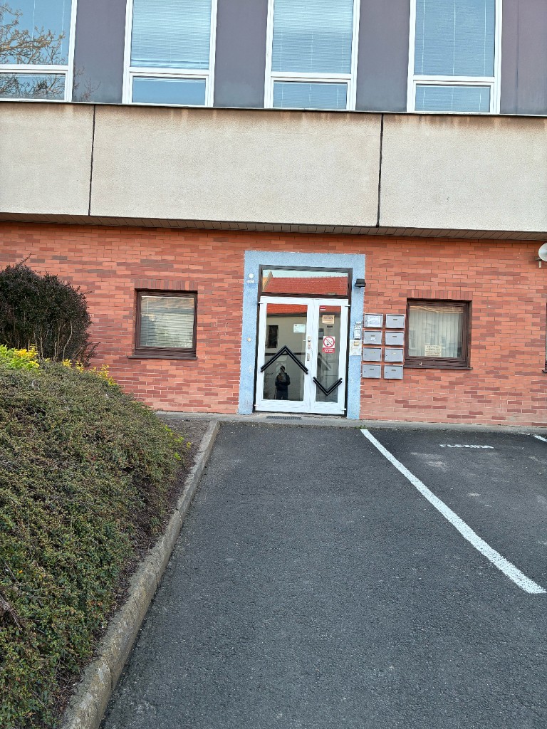 Vstupní prosklené dveře do domu se schránkami.